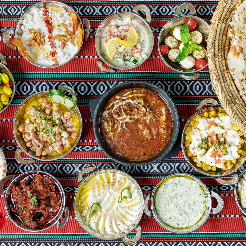 Bowls of hummus, foul, fatteh and labneh on the breakfast table
