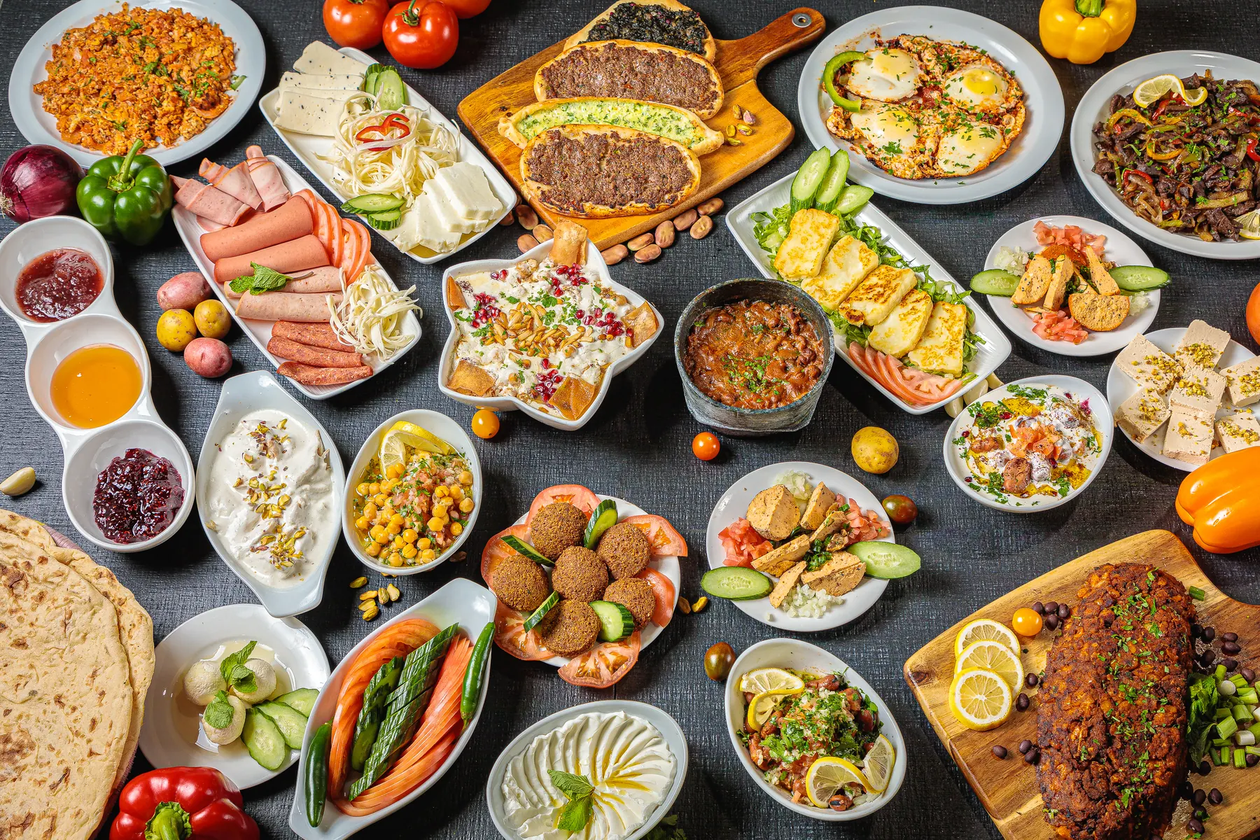 A table full of mezze, breakfast dishes and bread at Jerusalem Shawarma
